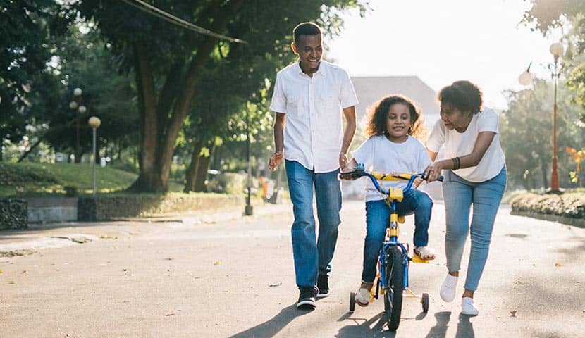 Familia paseando son su hijo en bici